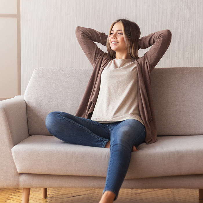 Young woman sitting on a couch for individual therapy in Pacifica, CA