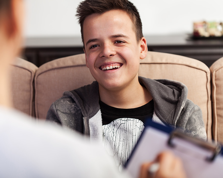 Teen sitting on a couch during therapy session in Pacifica