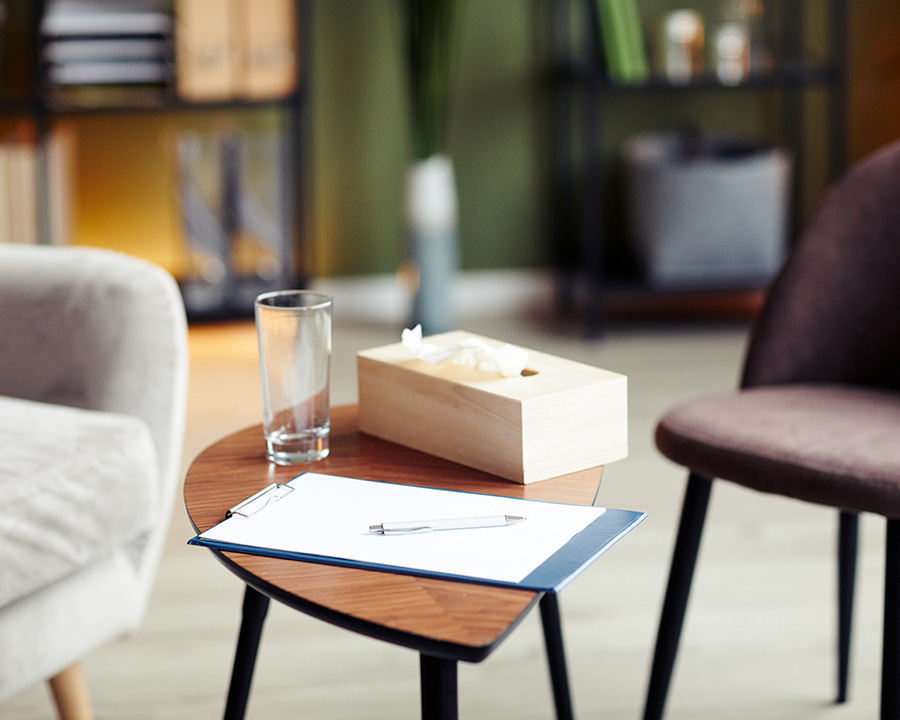 Therapy office with tissue box, chairs and clipboard.